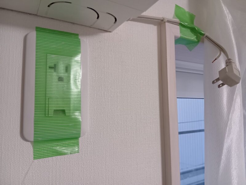 エアコン電源プラグを抜き、コンセント絵汚養生するイメージ