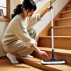 日本人女性が短いヘッドのモップを使い、木製の階段の角や端をスムーズに掃除している様子。狭い場所での操作性が高いことがわかる。