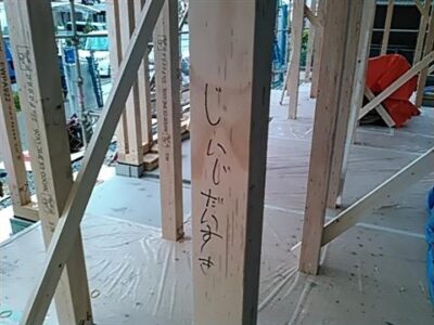 上棟式。木造住宅の骨組みにマジックで絵を描いている